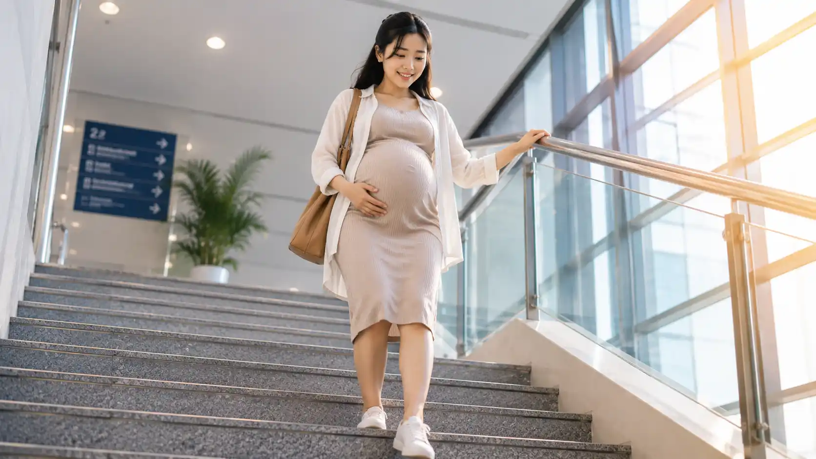 Woman carefully walking down stairs holding the handrail